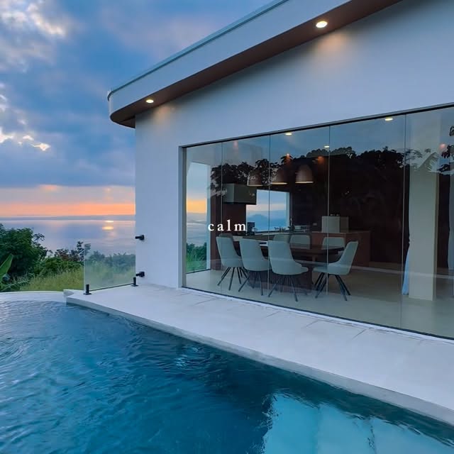 Dusk pool and illuminated dining room interior