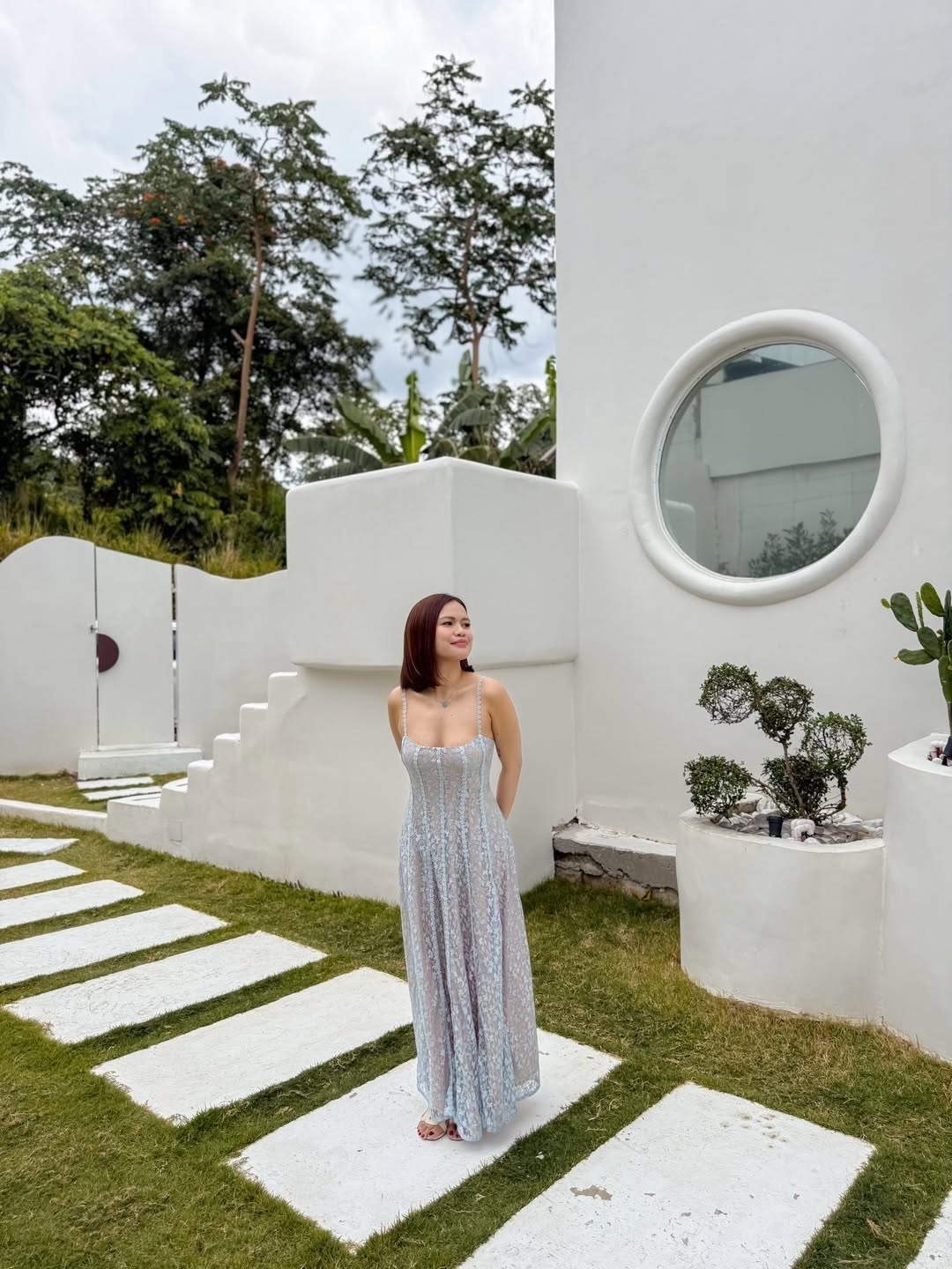 Villa exterior with circular porthole window and cascading garden staircase
