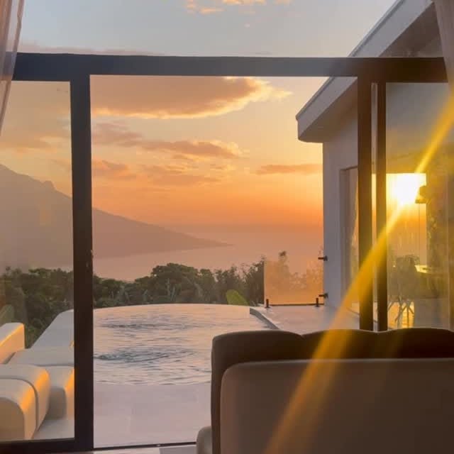 Sunset view through glass walls and pool